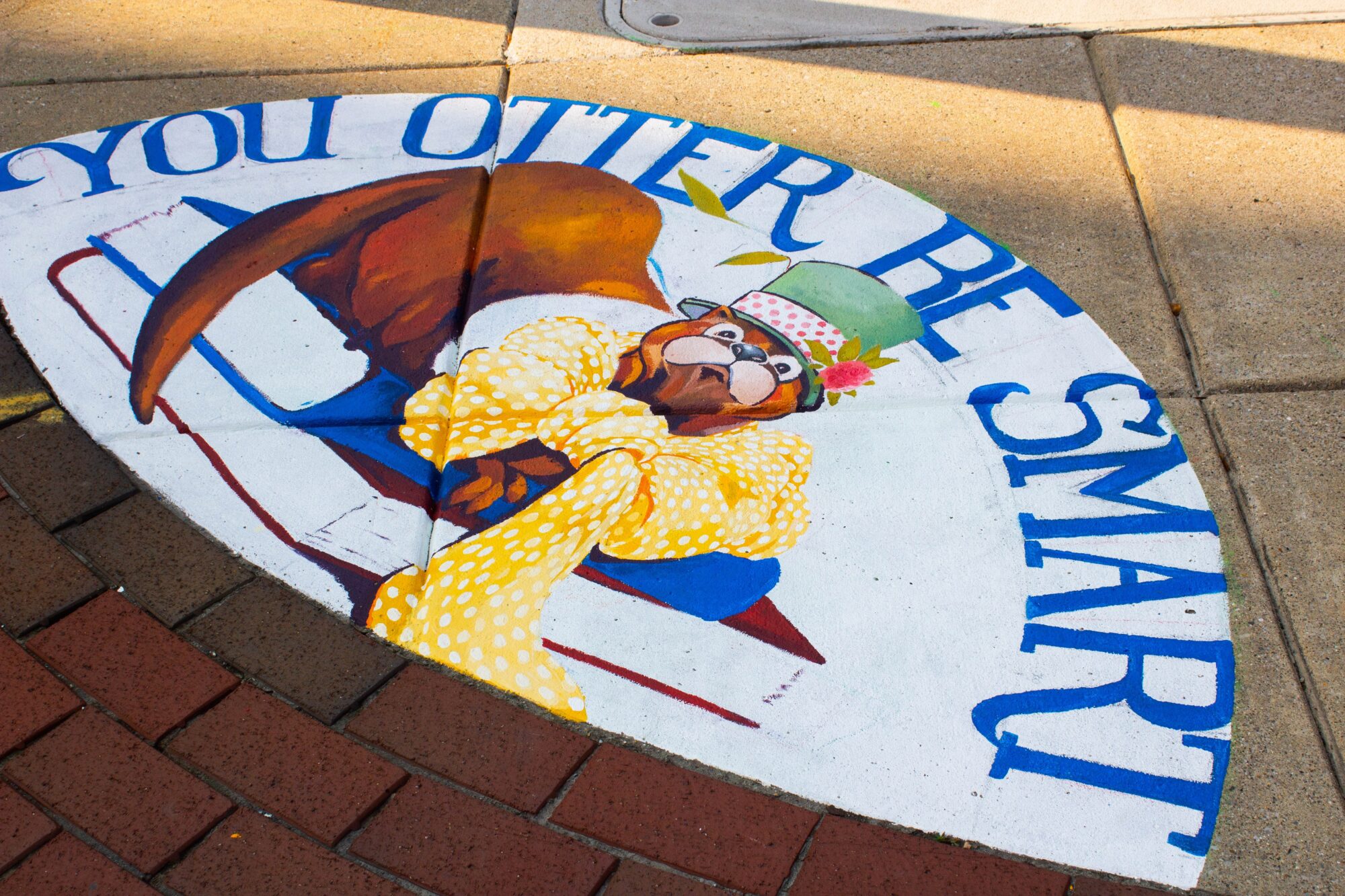 Clean Drains mural depicting an otter on top of books that says "You Otter Be Smart".