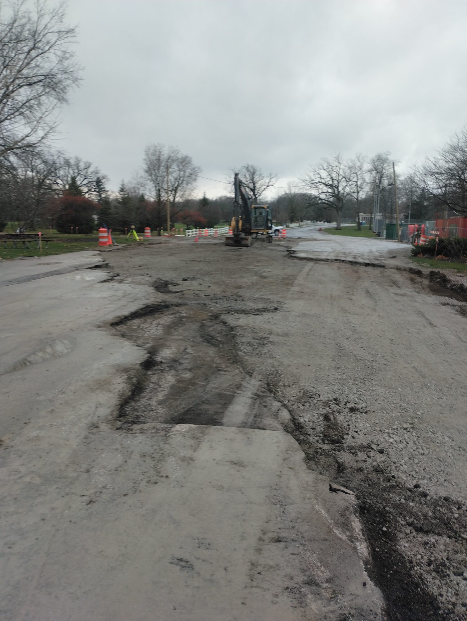 Photo of construction crew prepping for asphalt restoration using a backhoe.