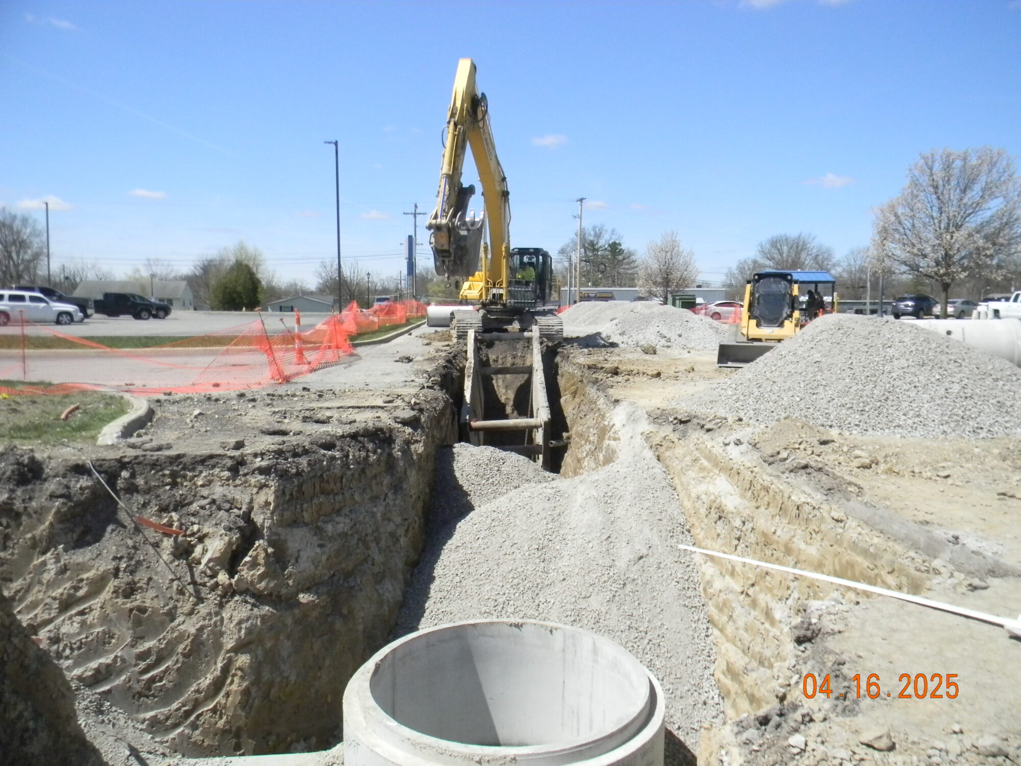 Bulldozer seen at a pipe installation site. The grass is torn up and the sediment is exposed.