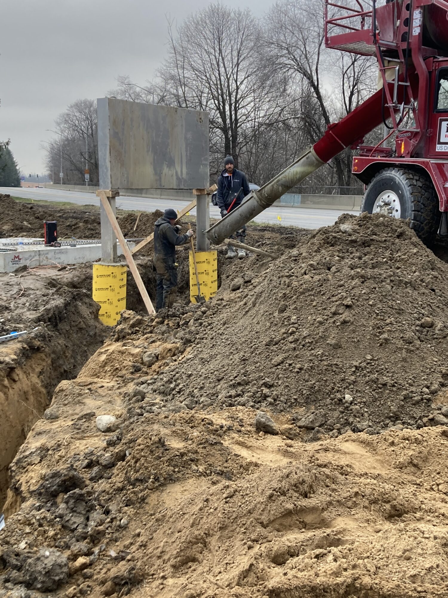 Construction crews working in a dug up pit with equipment in the Foster Park relief sewer area.