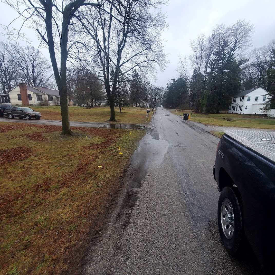 Neighborhood street showing stand still water.