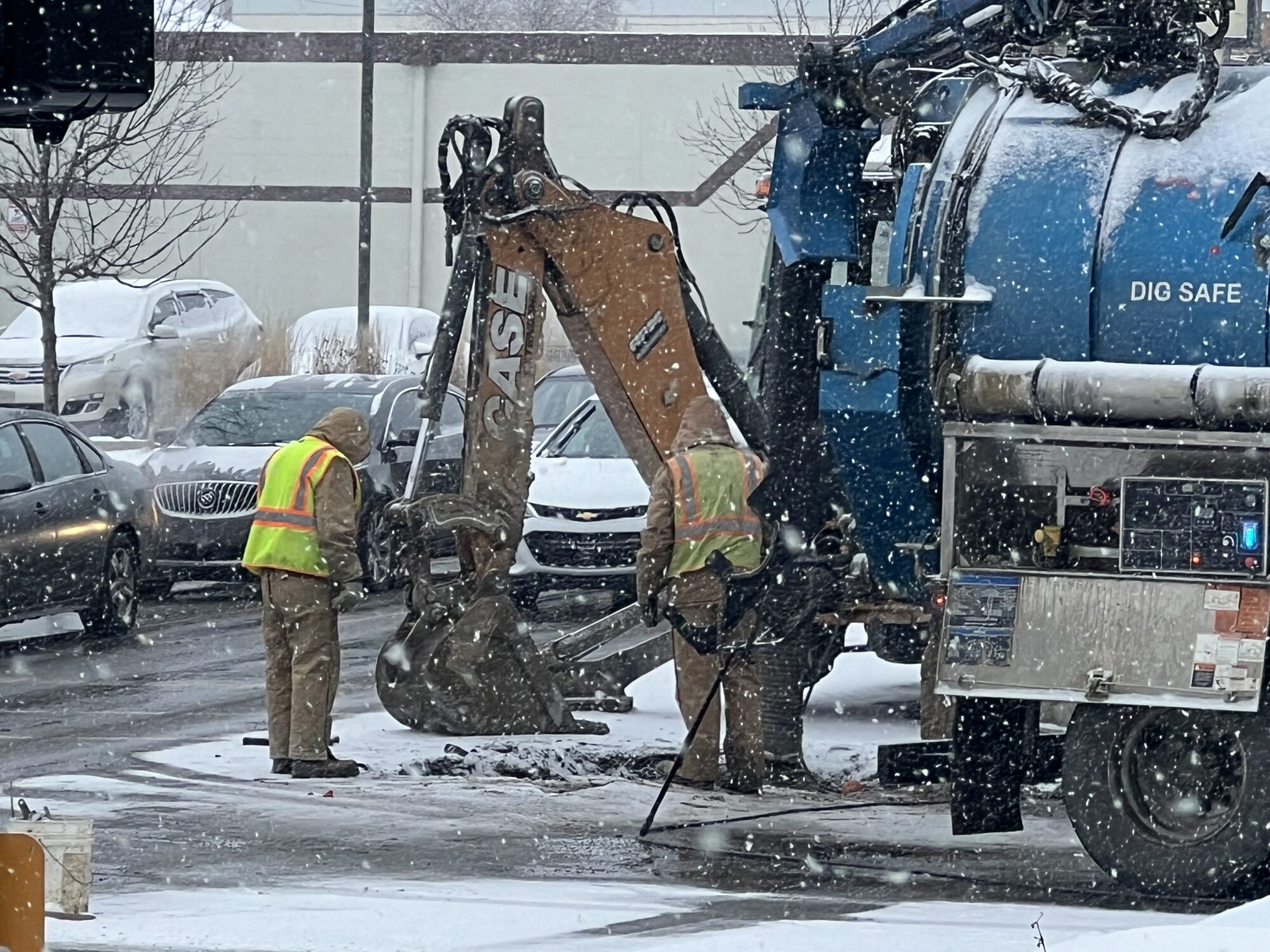 Construction crews with heavy equipment on a street.