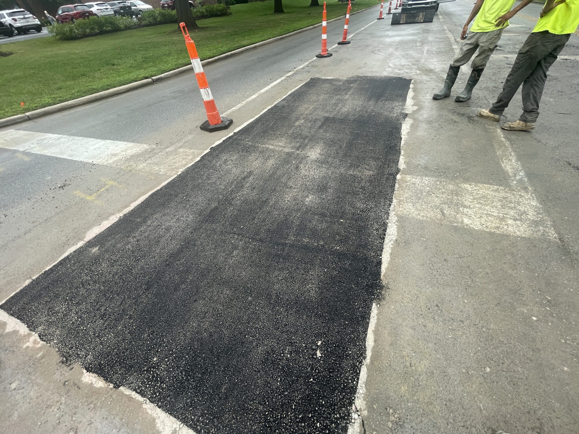 Black asphalt patch in the middle of the street.