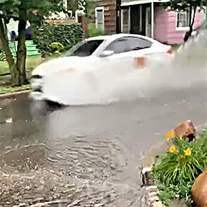 White car in high wateron the street.