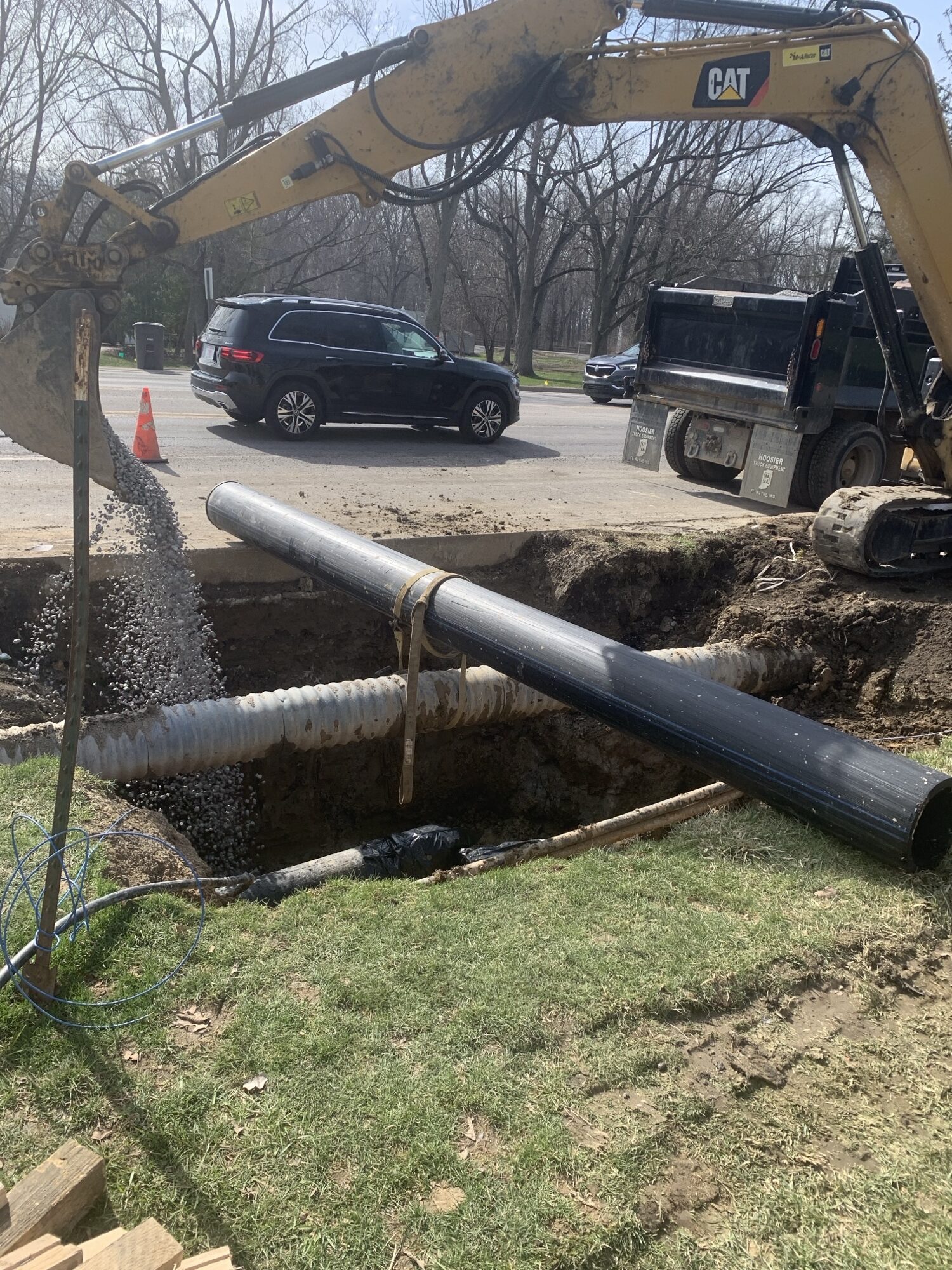 Shot of a new water pipe being placed by a bulldozer on a busy street.