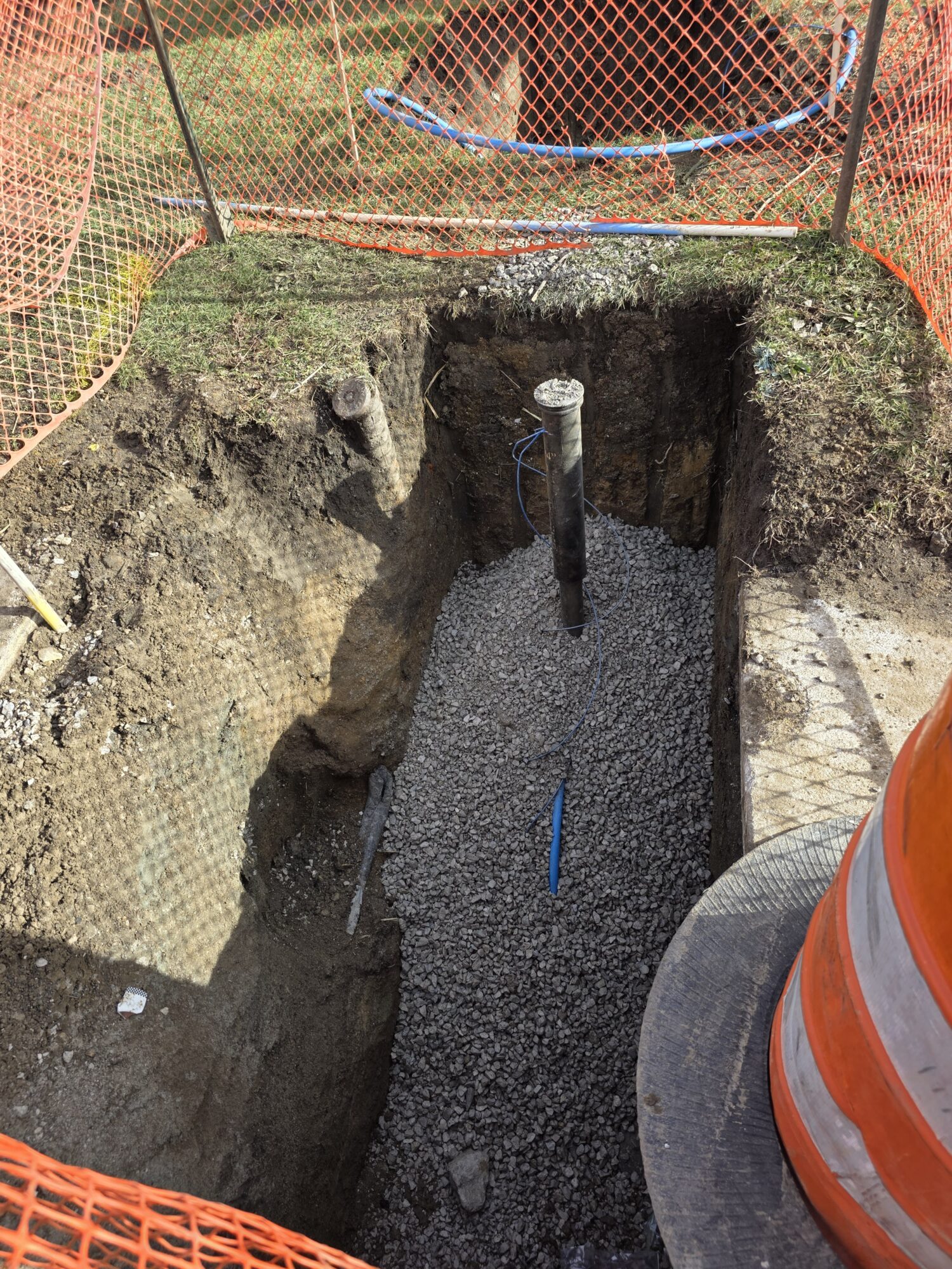 Dug-out hole being filled with gravel after construction.